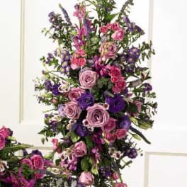 Tall floral spray with pink and purple roses and small purple blooms