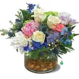 Mixed bouquet of roses, daisies, and blue flowers in a glass vase