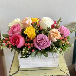Colorful rose arrangement in a white wooden box