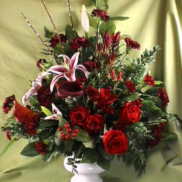 Red roses and lilies arranged in a white vase