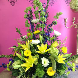 Tall mixed floral arrangement with yellow lilies and white daisies