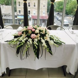 Low floral centerpiece with pink and white flowers on a table
