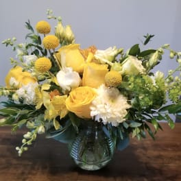 Yellow and white floral arrangement in a glass vase