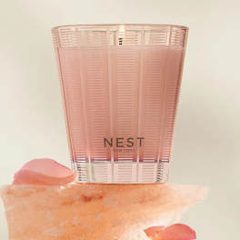 Pink Nest New York candle in a translucent holder with rose petals