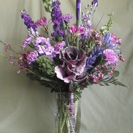 Purple and pink mixed bouquet in a clear glass vase