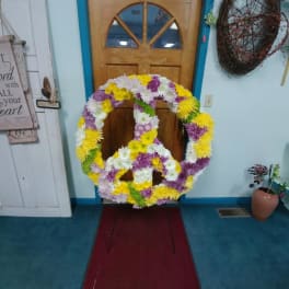 Large floral peace sign made of yellow, white, and purple flowers