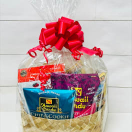 Assorted Hawaiian snacks in a woven gift basket wrapped in cellophane with a red bow