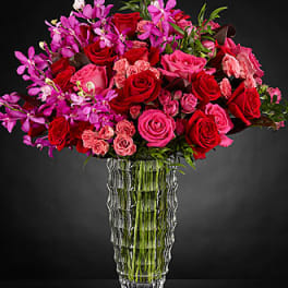Bouquet of red and pink roses in a clear glass vase