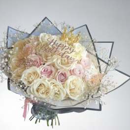 Bouquet of cream and pink roses with a "Happy Birthday" topper