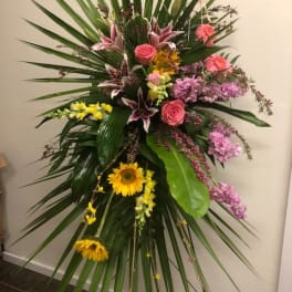 Tall standing floral spray with pink, yellow, and purple flowers