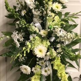 Tall white and lime-green floral standing spray on an easel