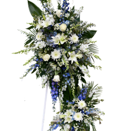 Standing floral spray with white and blue flowers on a white easel
