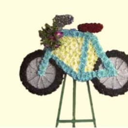 Flower-covered motorcycle sculpture on a stand
