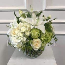 White floral arrangement in a round glass vase