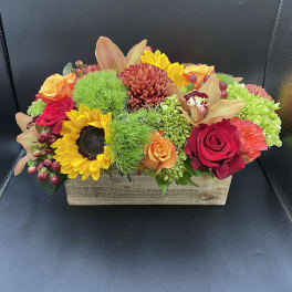 Colorful mixed flower arrangement in a rectangular wooden box