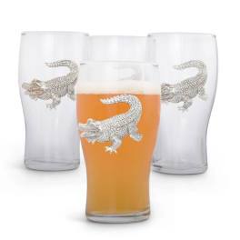 Four clear drinking glasses with silver alligator designs