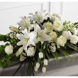 White floral casket spray with lilies and roses