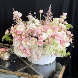 Large pastel floral arrangement in a white round box