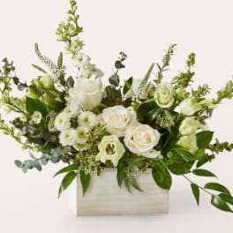 White roses and pale green flowers in a wooden box