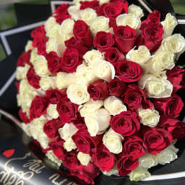 Large bouquet of red and white roses wrapped in black paper
