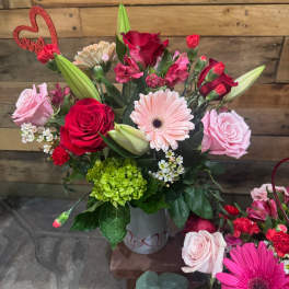 Bouquet of red and pink roses with gerbera daisies in a vase