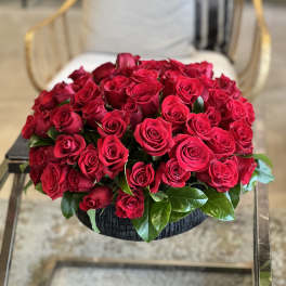 Round bouquet of red roses in a black basket