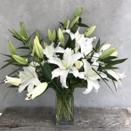 White lilies arranged in a clear glass vase