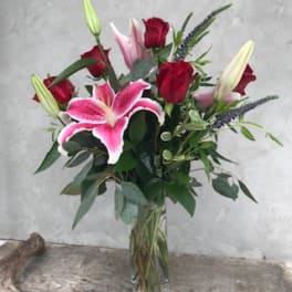 Bouquet of red roses and pink lilies in a glass vase