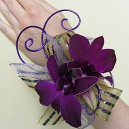 Purple orchid wrist corsage with ribbon on a wrist