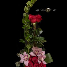 Tall floral arrangement with red roses and pink orchids in a vase