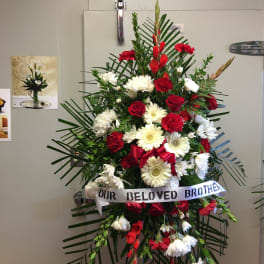 Standing red and white funeral spray with ribbon tribute