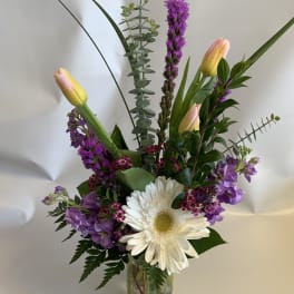 Mixed bouquet with white daisy and pink tulips in a glass vase