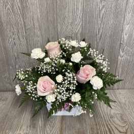 Pink and white rose arrangement in a white box
