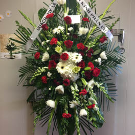 Standing funeral spray with red and white flowers on an easel