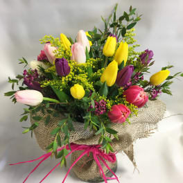 Bouquet of multicolored tulips in a burlap-wrapped vase