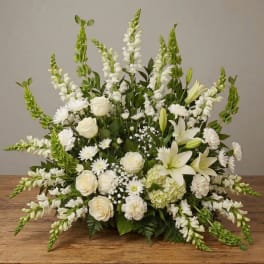 White floral arrangement with lilies, roses, and tall snapdragons