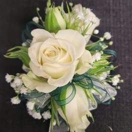 White rose corsage with green ribbon and small white filler flowers