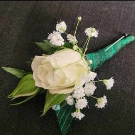 White rose boutonniere with baby's breath and green ribbon wrap