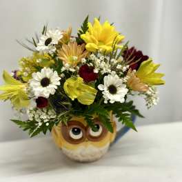 Bouquet of mixed flowers in an owl mug