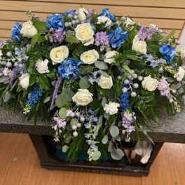 Large floral arrangement with white and blue roses on a stone table