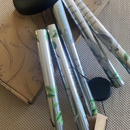 Silver wind chimes with black hanging parts and a cardboard box