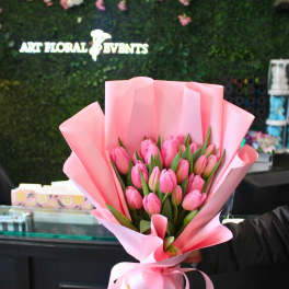 Pink tulip bouquet wrapped in pastel pink paper with a ribbon
