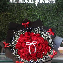 Bouquet of red roses with baby's breath and black wrapping