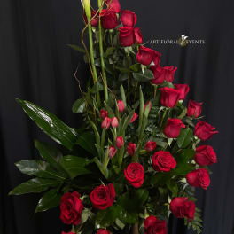 Tall arrangement of red roses and pink tulips with white calla lilies