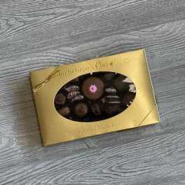 Box of assorted chocolates with a gold wrapper and window cutout