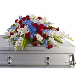 Red, white, and blue floral spray on a silver casket