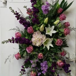 Tall floral spray with pink roses, white lilies, and purple blooms