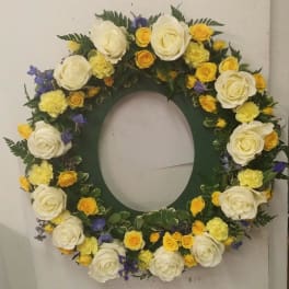 Circular floral wreath with white, yellow, and purple flowers