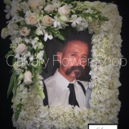Large white floral funeral frame with a portrait in the center