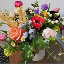 Mixed bouquet of colorful flowers in a white vase
